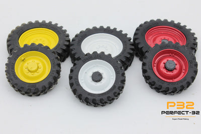 Set of five toy wheels in yellow, white, and red on a light gray background