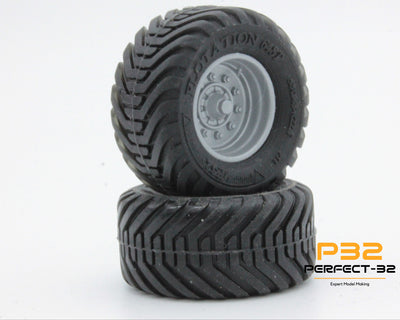Two black off-road tires with tread patterns on a white background