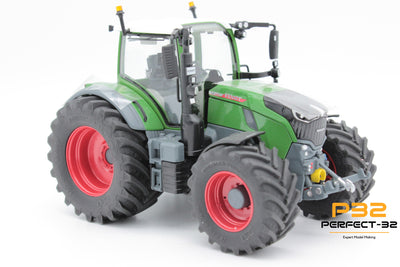 Toy tractor with green body, gray tires, and red rims on a white background