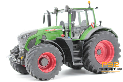 Model tractor with green body and red wheels on a white background