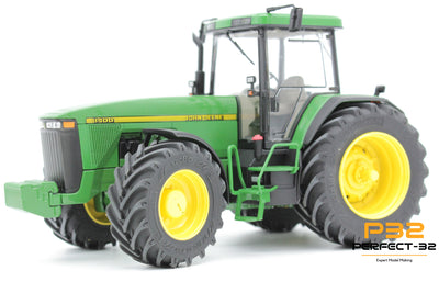 Model of a green tractor with yellow wheels on a white background